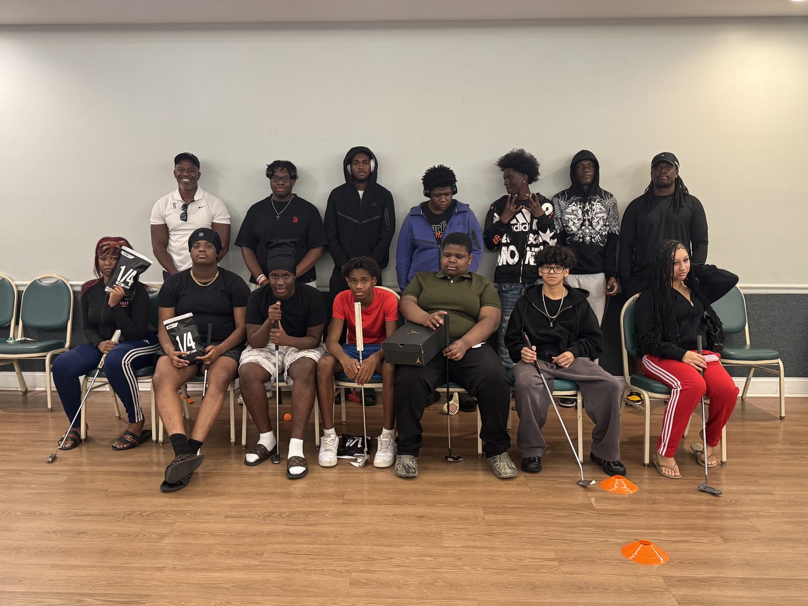 Group of FFGF youth participants indoors with golf clubs and program gear
